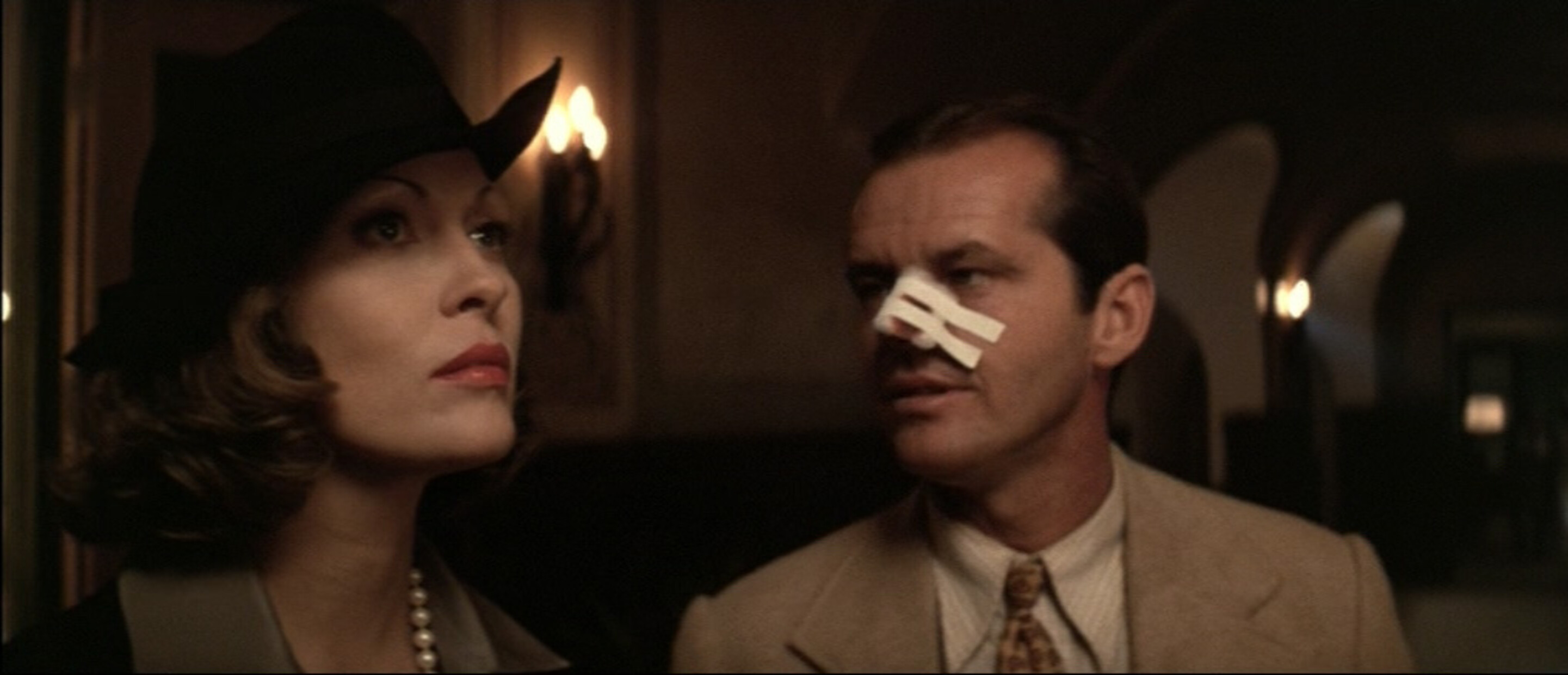 Man with his nose taped up starting at a woman