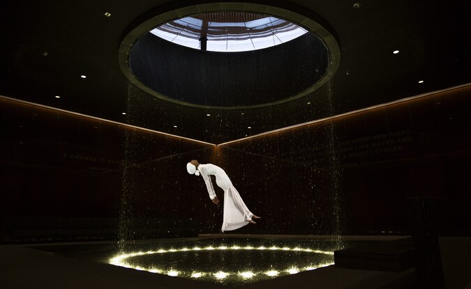woman in white floating in black room