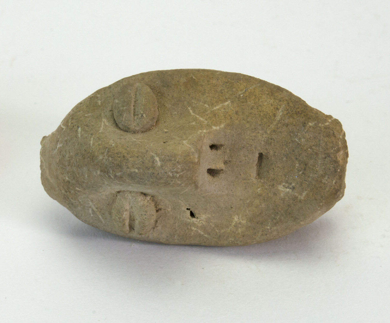 Figureine of a head made of clay laid on its side