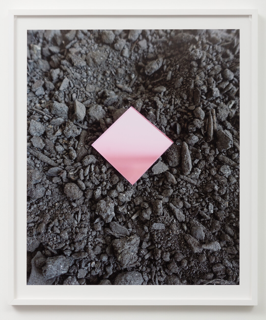 Pink diamond glass in middle of black rocked ground