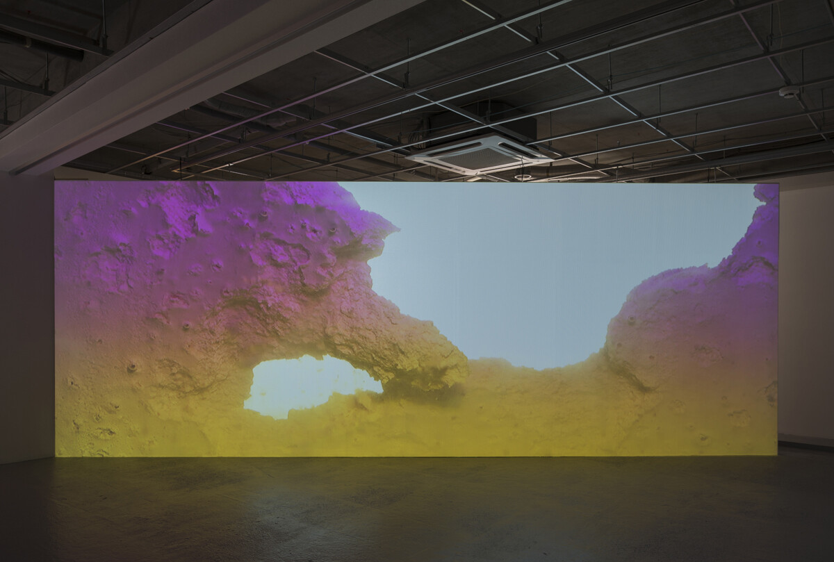 Video installation showing image of geological like landscape in gallery