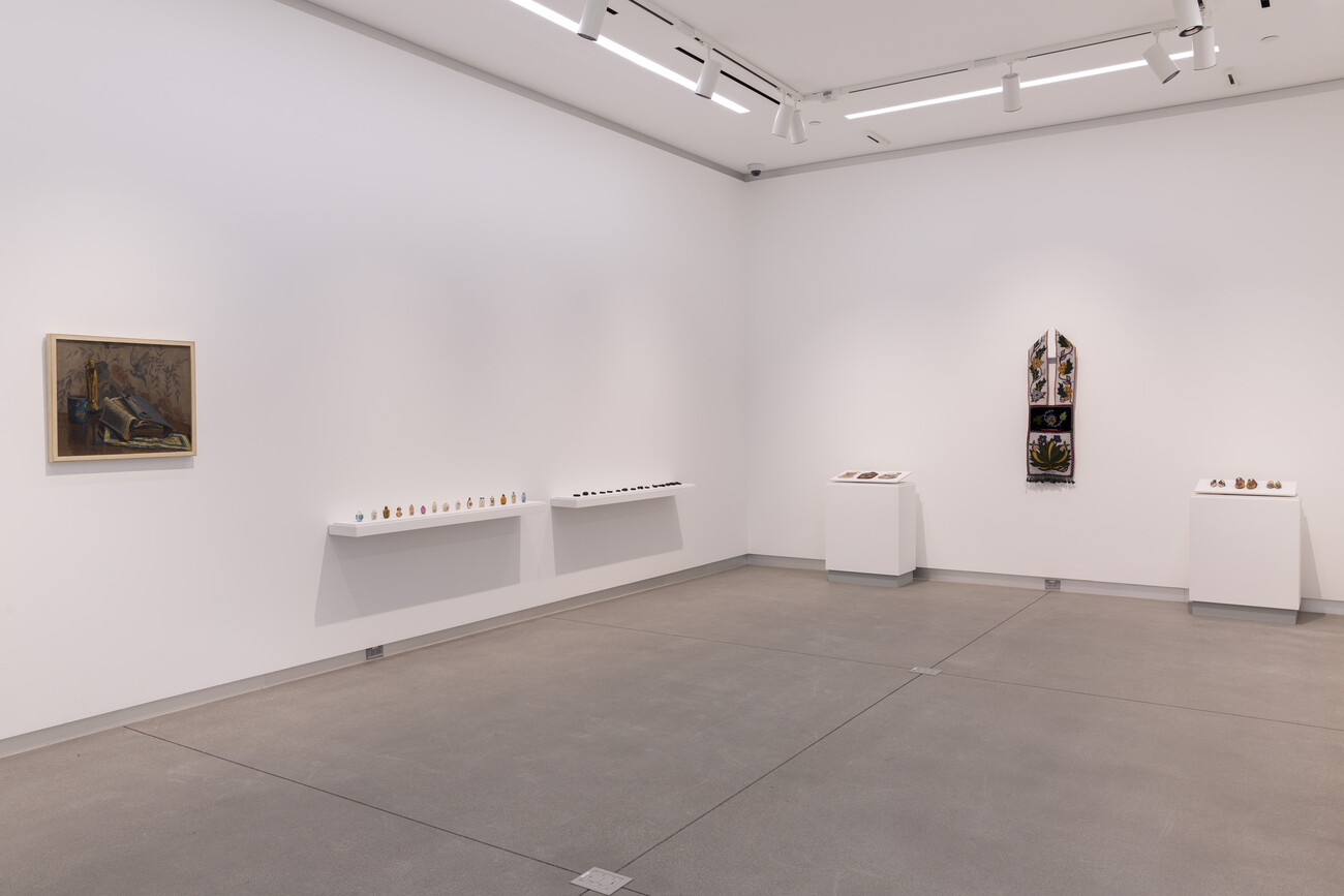 Works of art laid across wall mount and pedestals and additional works installed on gallery wall