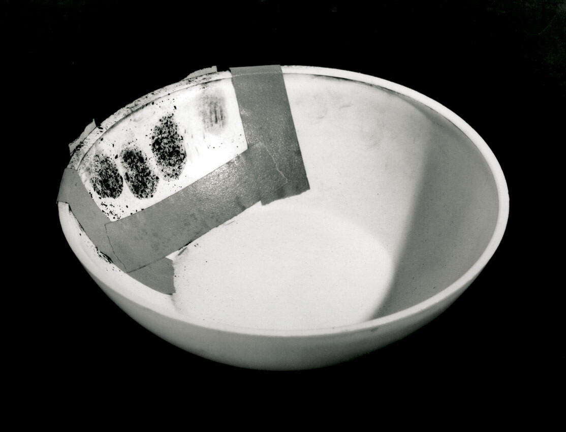 John Baldessari, Evidence: Bowl Handed to Helene Winer Dec. 1, 70, 1970. Typed text, bowl, tape, and lamp black. (Bowl was later destroyed.) Photo documentation: black-and-white photograph, 8 x 10.25 in. (20.3 x 25.4 cm). Collection of the artist