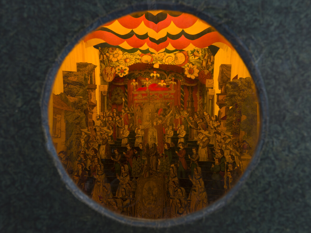 circle window into an orangey red scene of people in a room