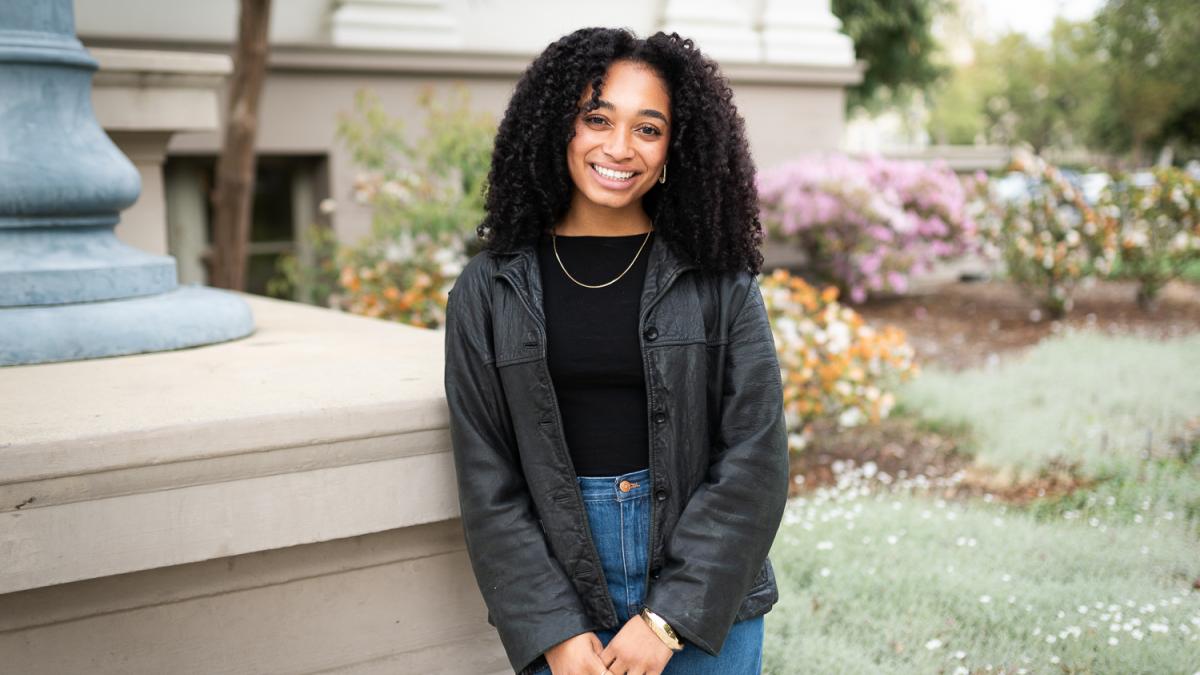 Nadiya Muhammad '25 standing in front of Carnegie building on Pomona College campus.