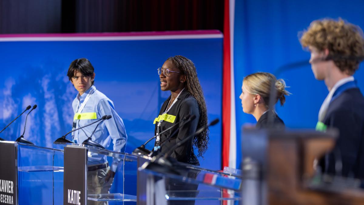 Students at podiums on stage
