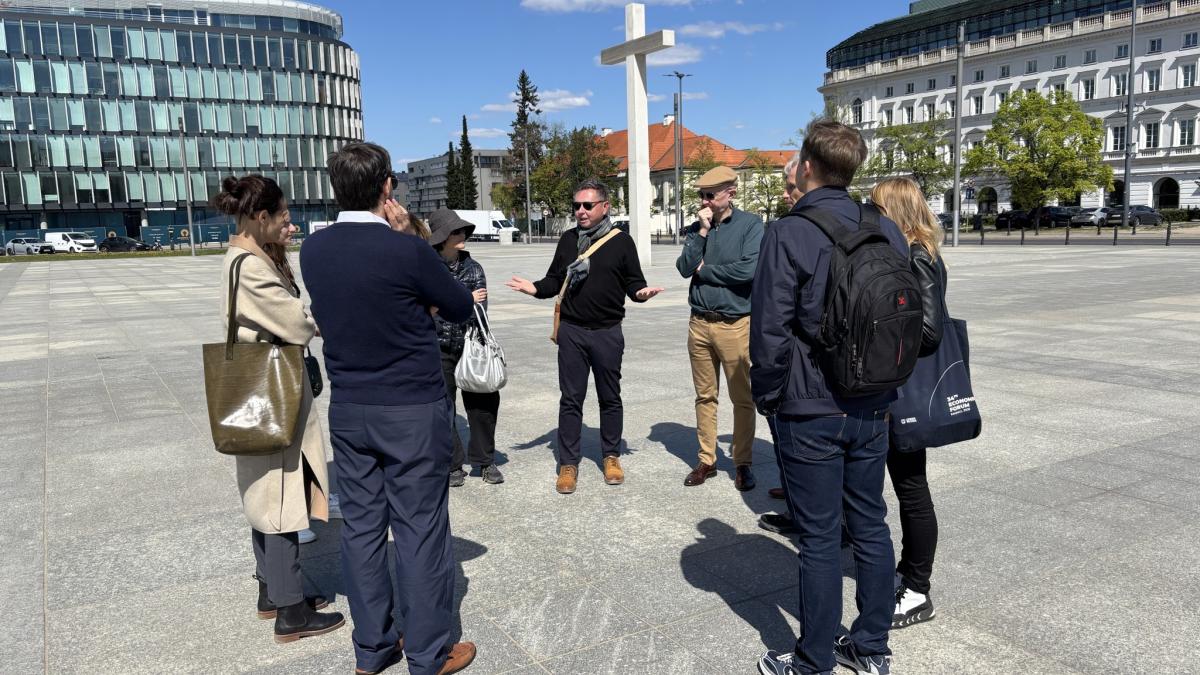 Mietek Boduszynski with tour group outside in Warsaw