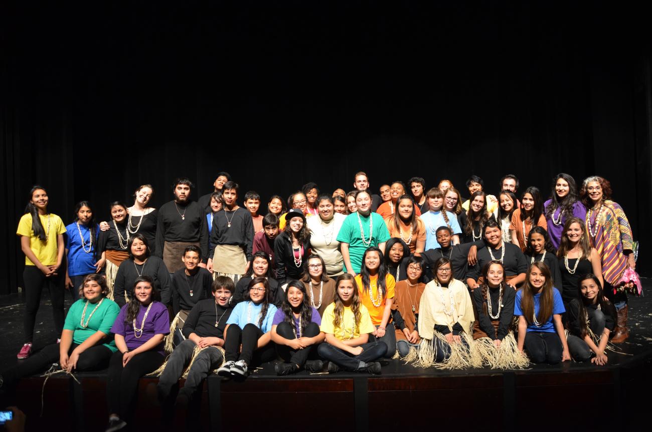 Students stand on stage for a picture