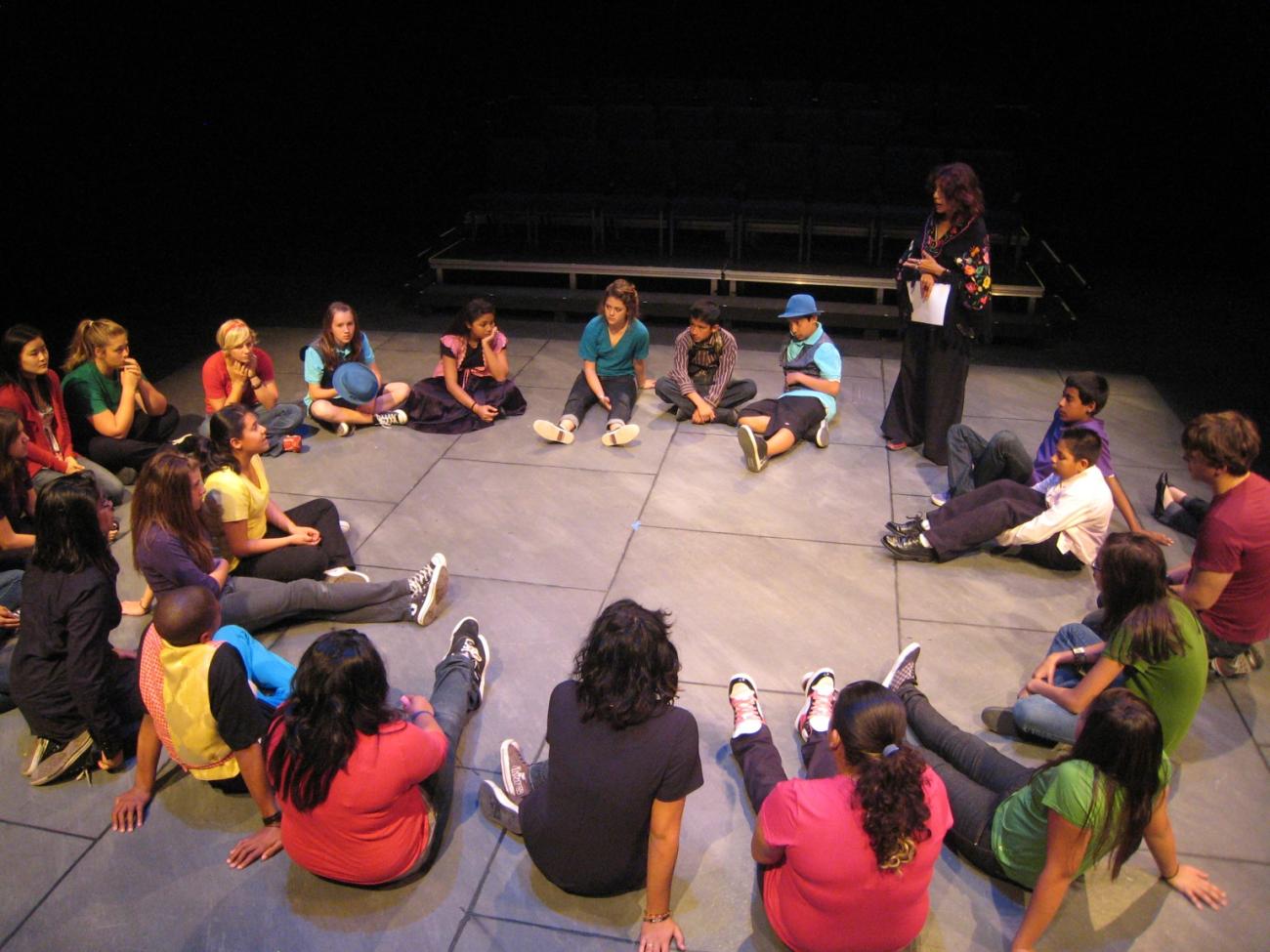 Rose Portillo '75 and a group of students sit in a circle