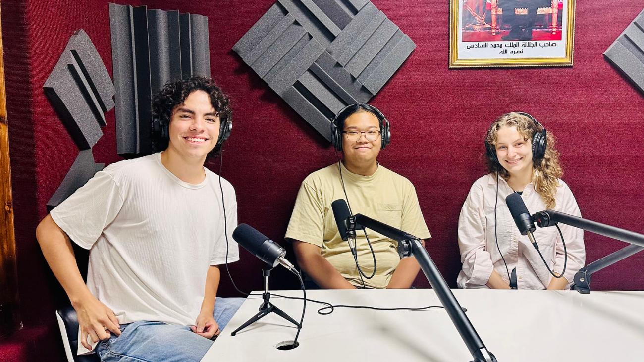 students sitting around a table with a radio microphone at an interview