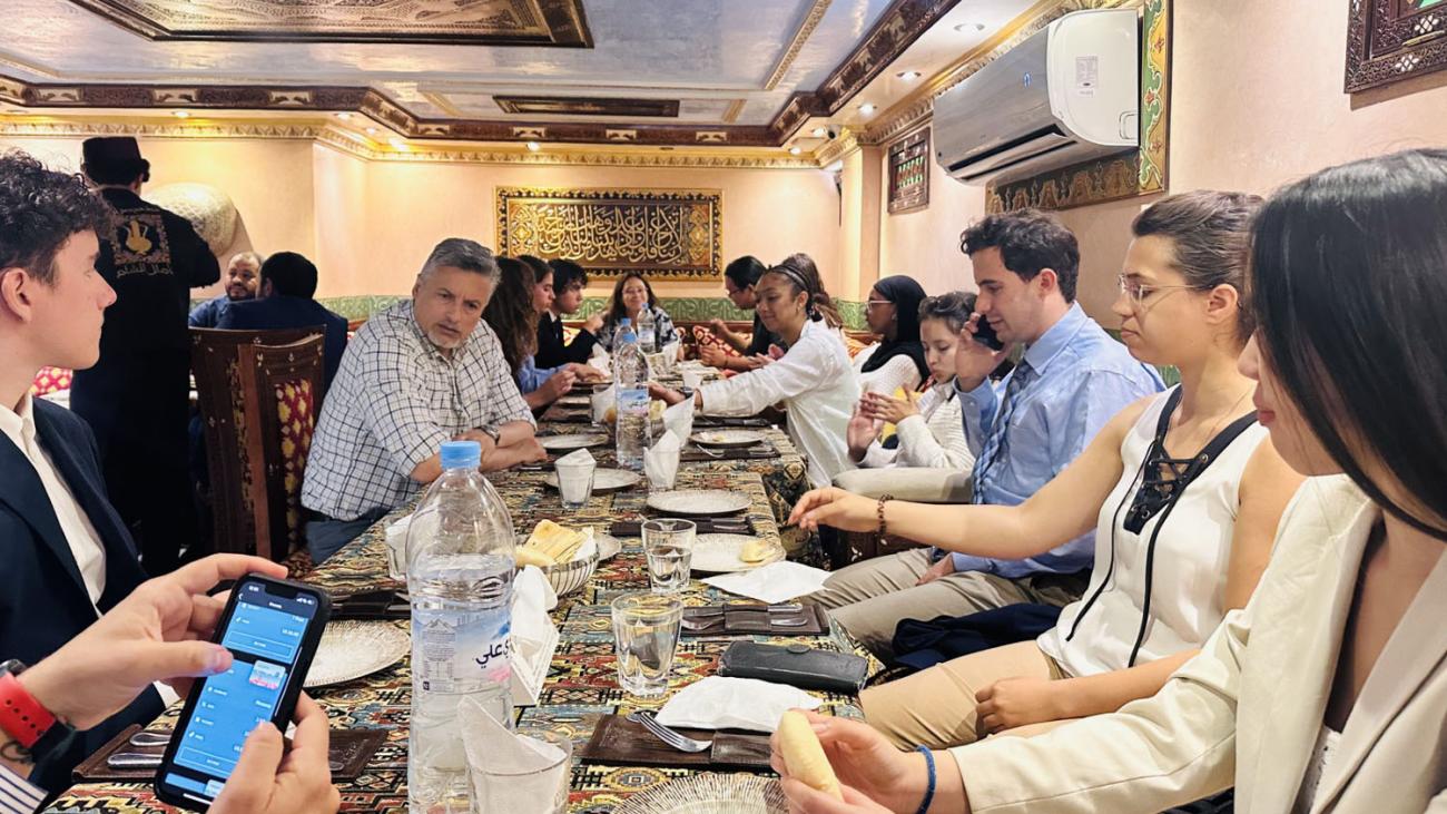 students seated around a long table eating a meal