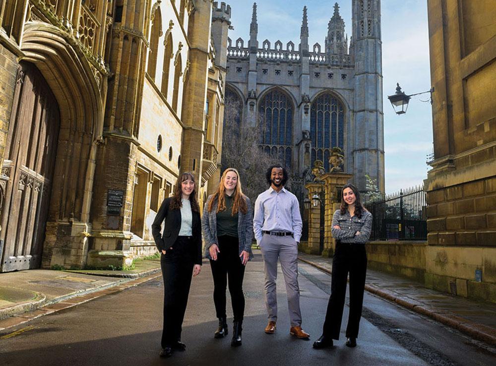Four Sagehens stand on a street in the historic core of Cambridge, England
