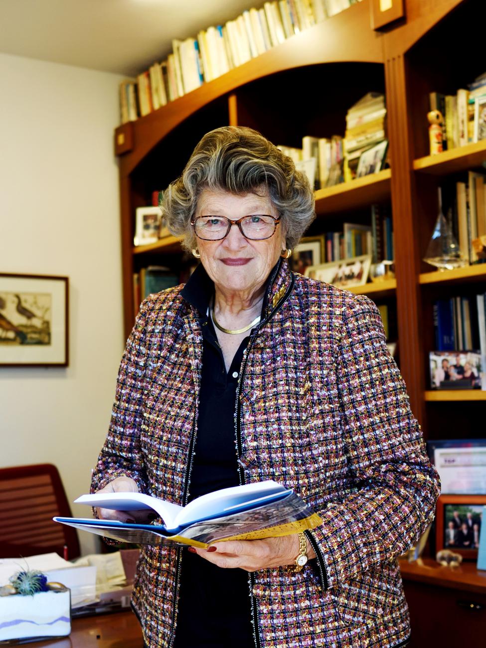 Photo of Blaisdell Award winner Mary Walshok, Class of 1964, in front of book cases