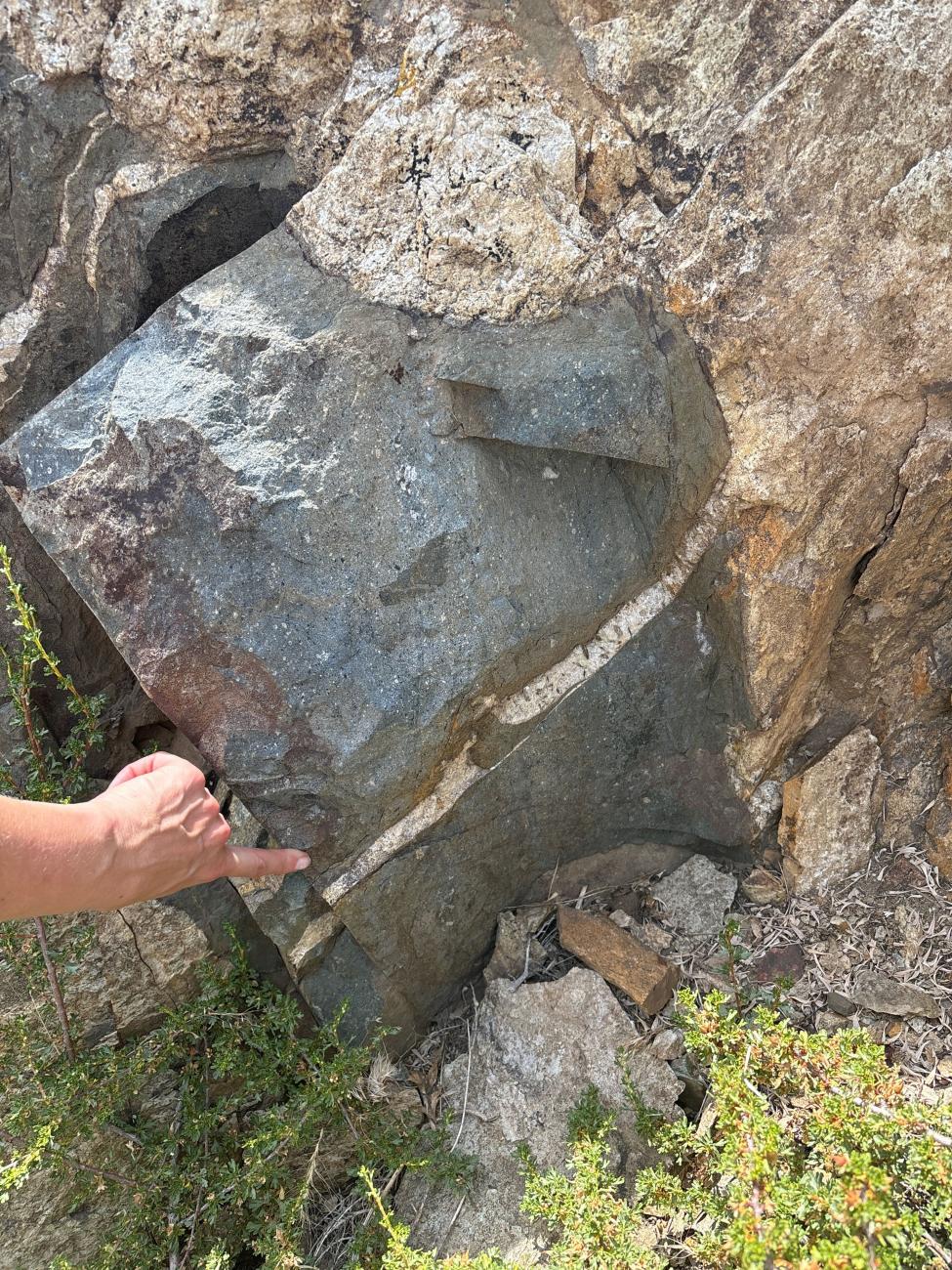 A person points at a rock