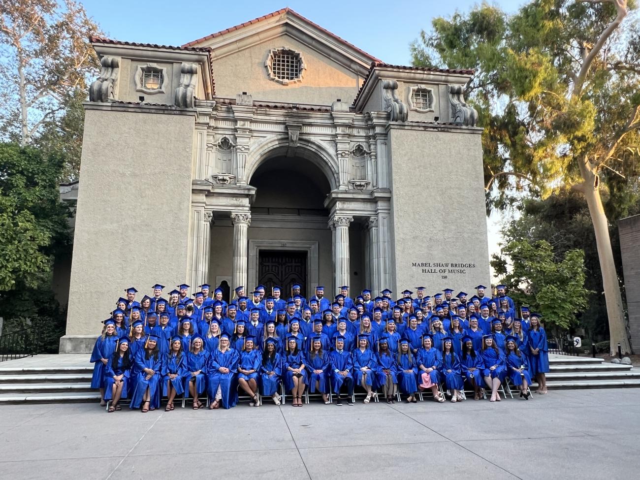 A graduating class sits in front of Little Bridges