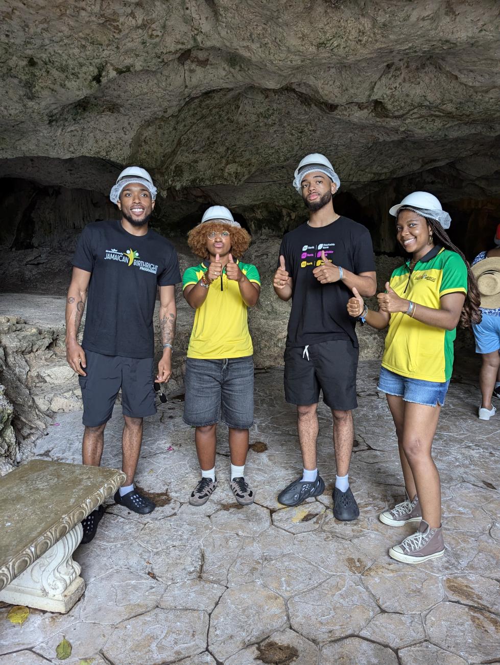 Four students stand in a cave