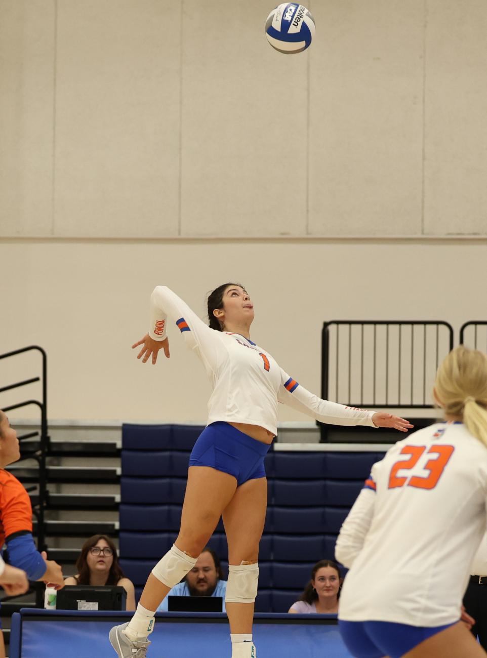 Chloe Gill jumps in the air to spike a volleyball