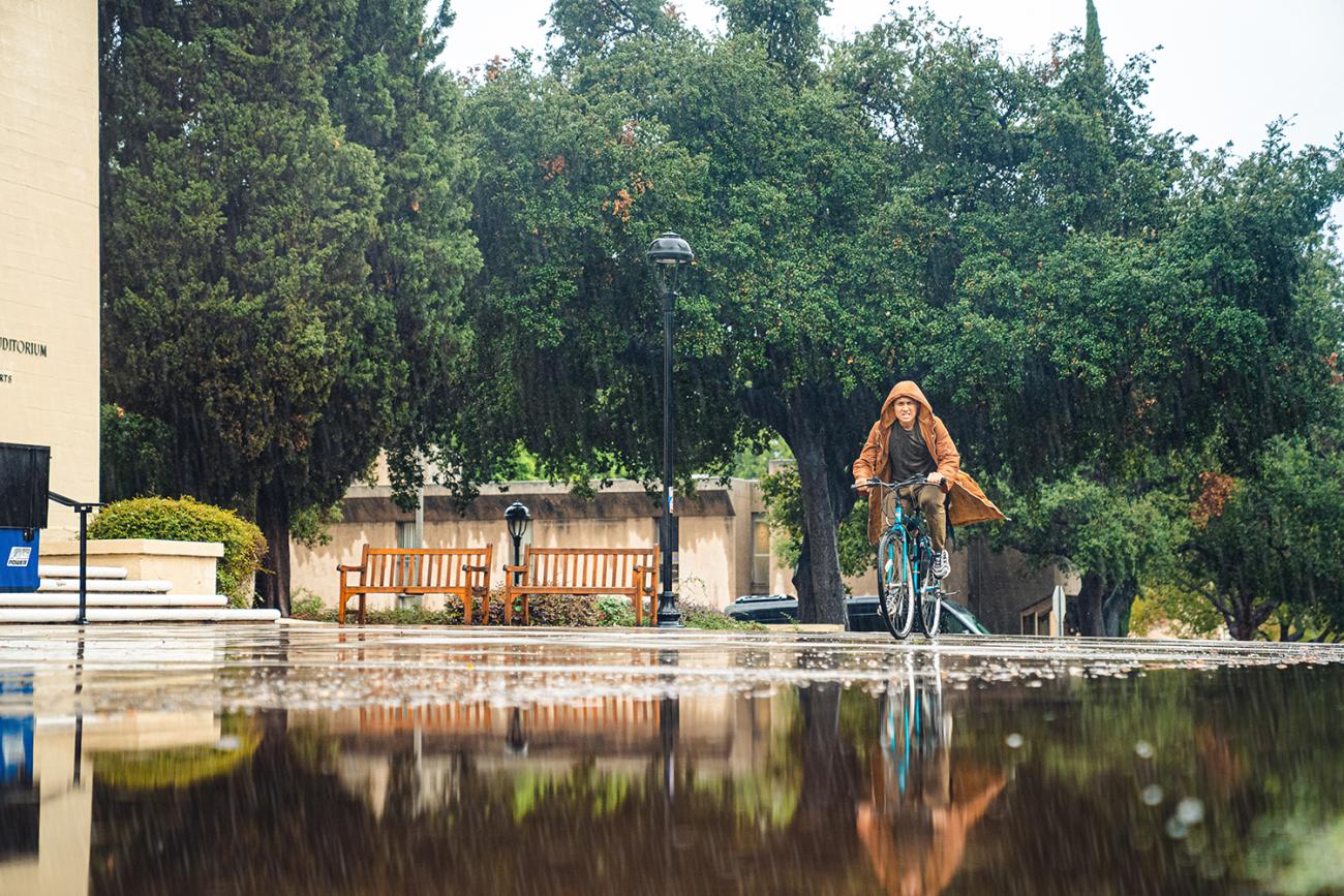 Student rides bike in rain