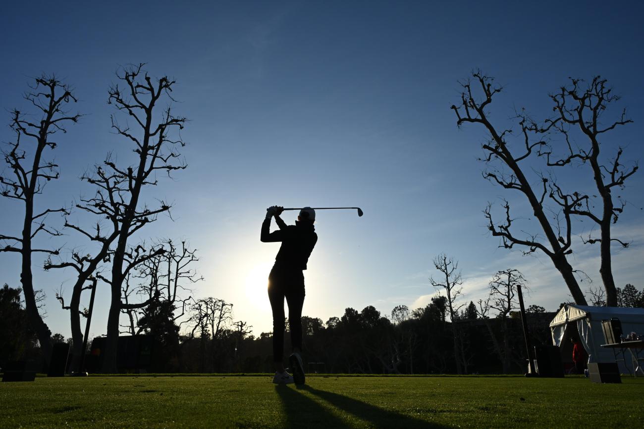 Gabby Herzig swings a golf club.