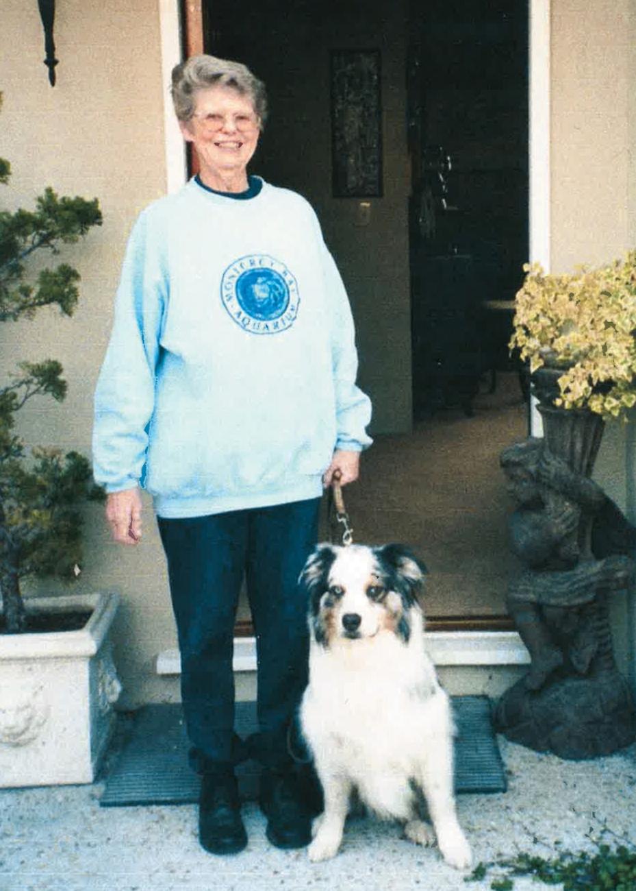 photo of alumna sharon russell class of 1952 with her dog in front of a doorway