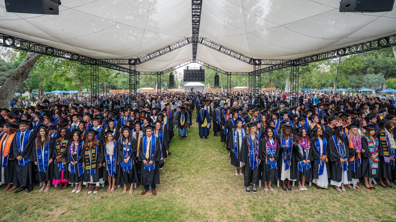 commencement 2026 group standing under the tent