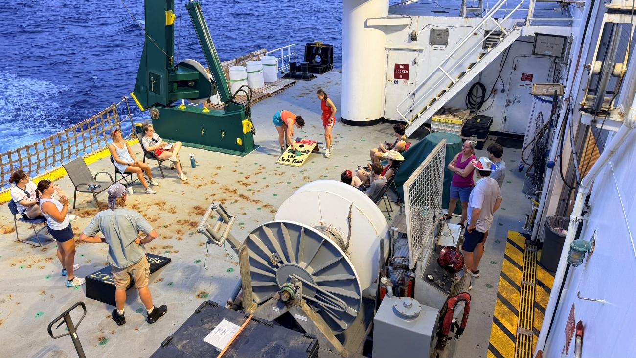 people playing cornhole on a ship's deck