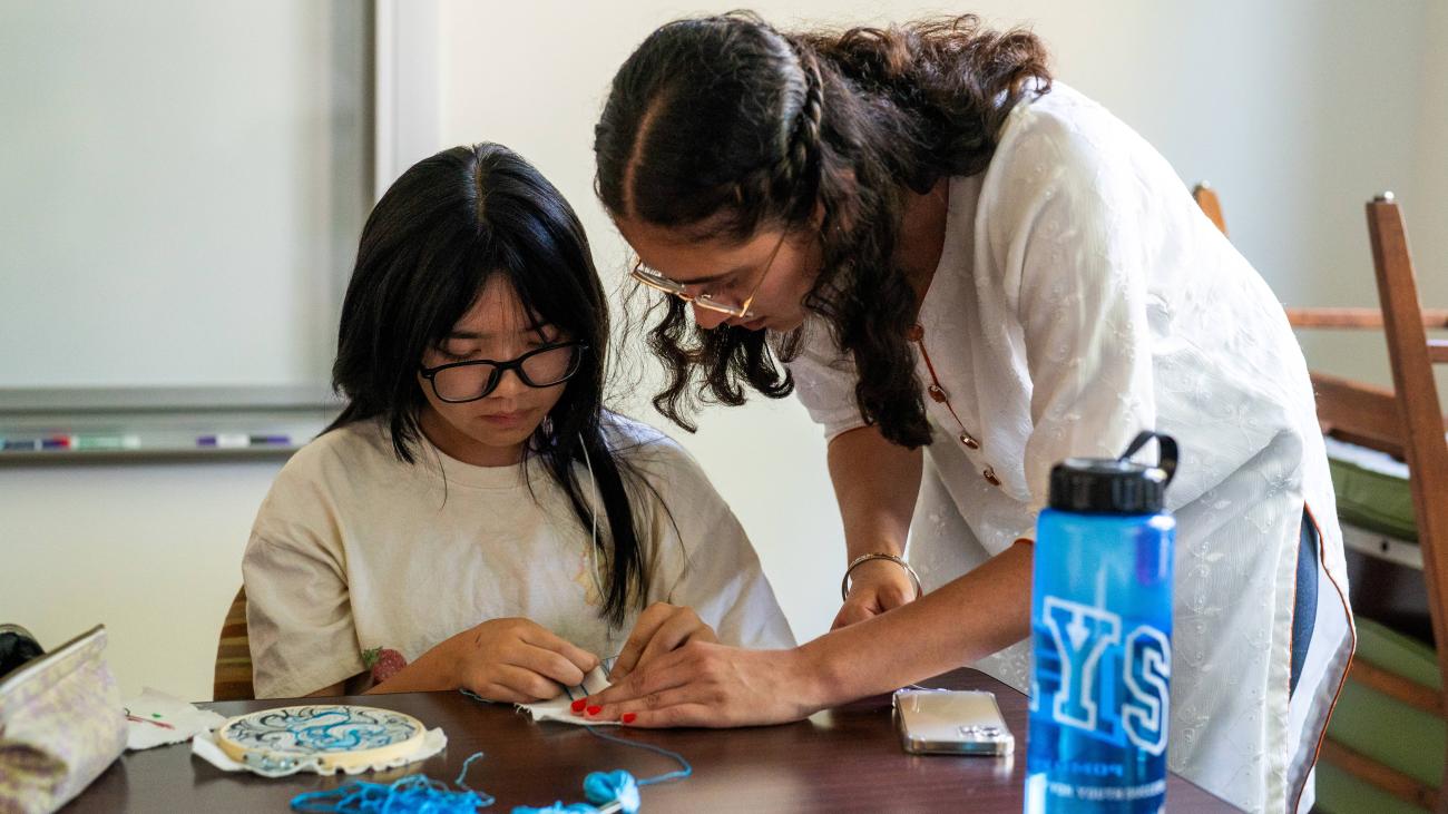 Current PAYS Scholar Abby Tran '25 learning how to stitch from PAYS Alumna Sarabjit Dhillon '22 in her elective class.