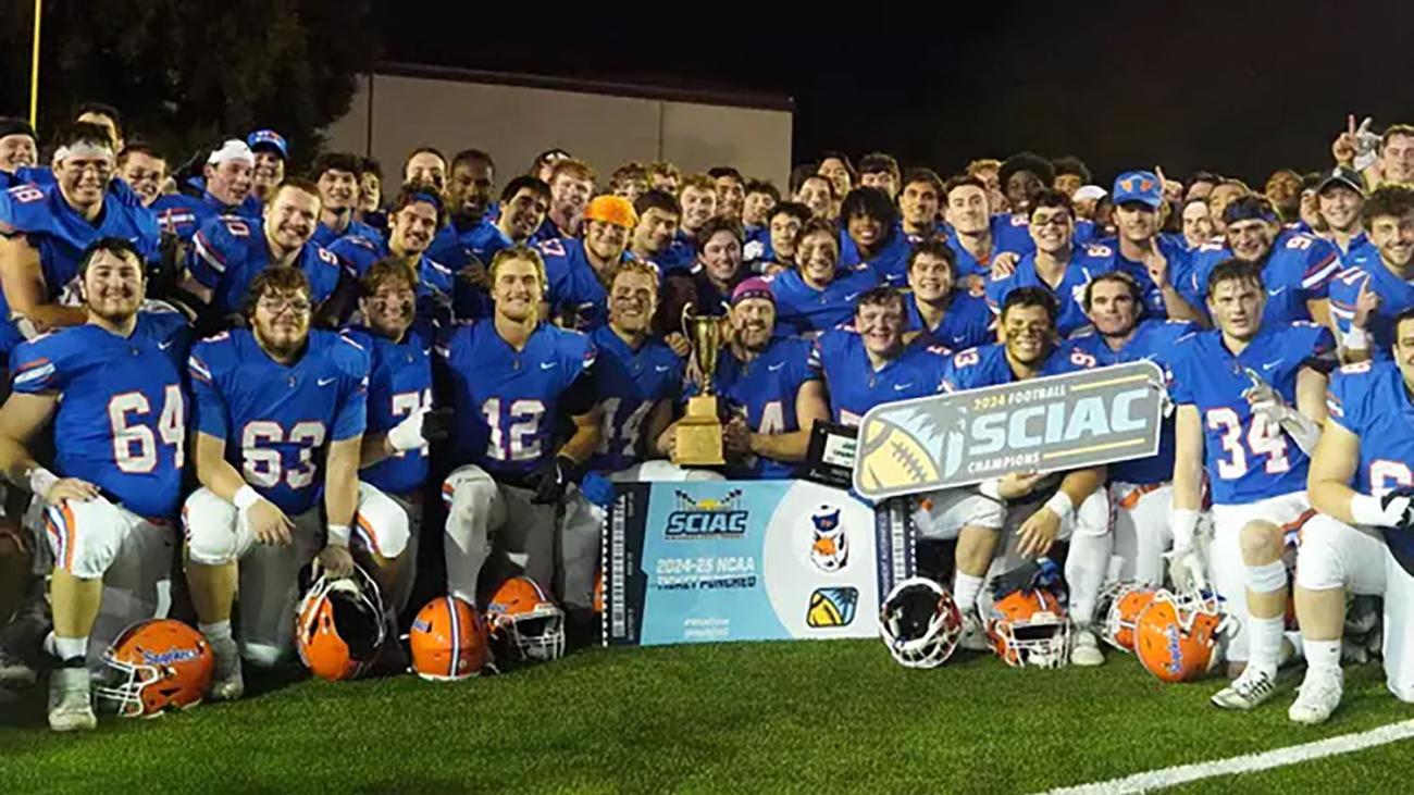Football team pose with championship trophy