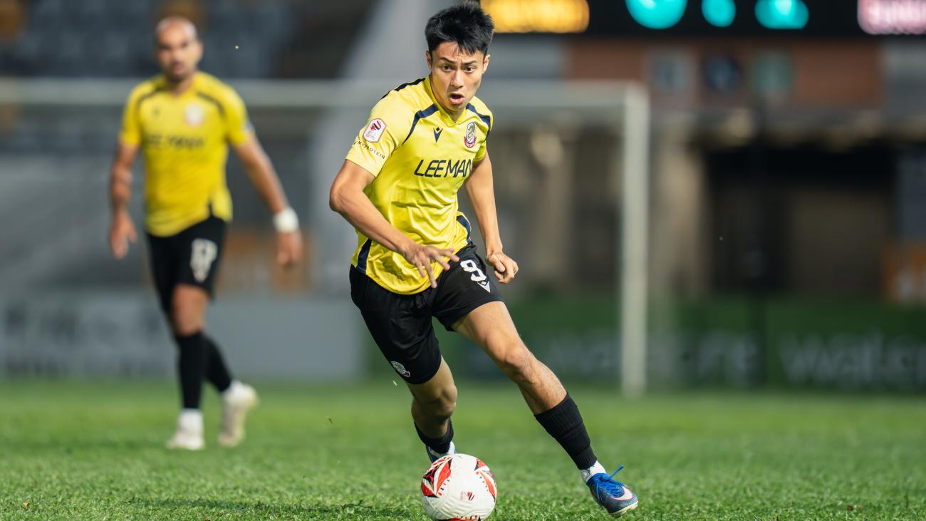 Kyle Lau dribbles a soccer ball
